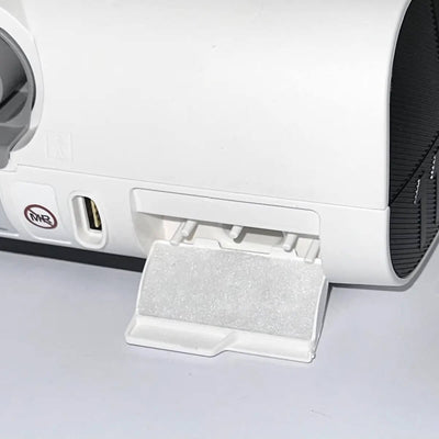 A close-up image of a white disposable filter attached to a CPAP machine, with a focus on the filter itself.